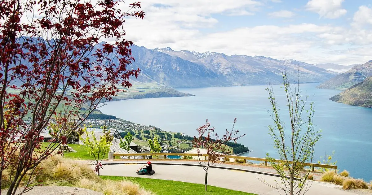 A luge cart on the Skyline Luge track above Queenstown, with Lake Wakatipu and the mountains beyond